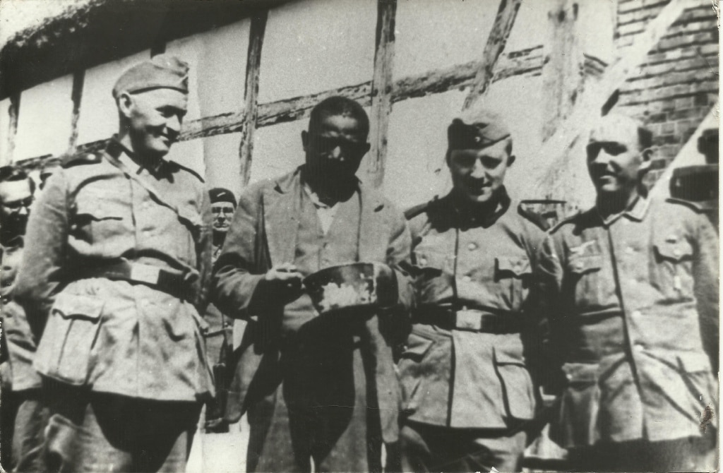 Ciemnoskóry jeniec w towarzystwie żołnierzy niemieckich.